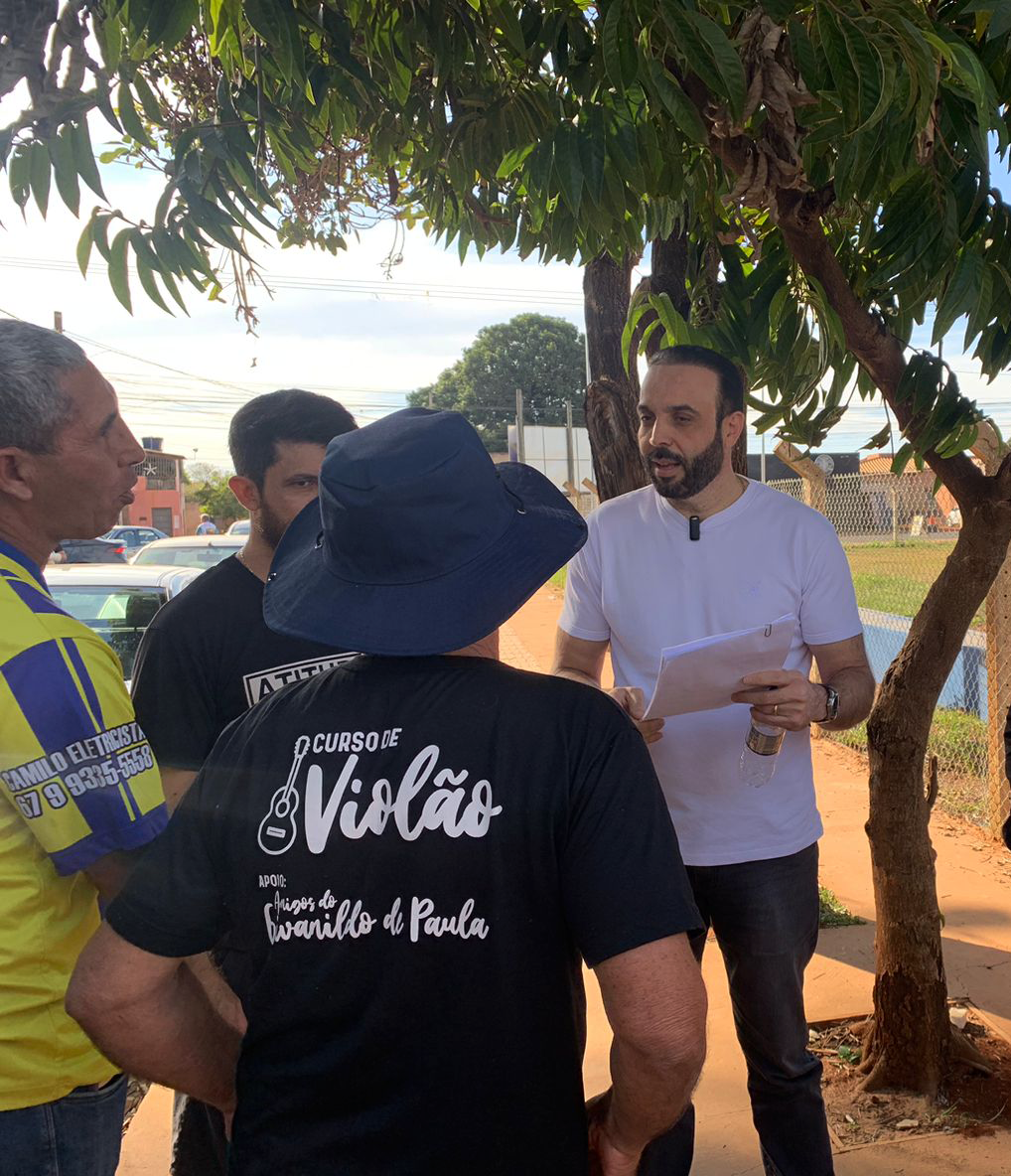 Professor Juari conversando com moradores embaixo de uma árvore